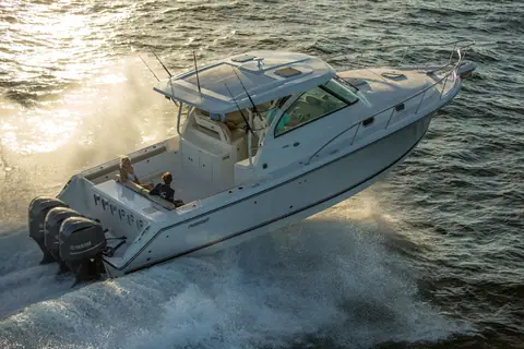 Pursuit OS 385 Offshore seen from the stern quarter at speed with triple Yamaha outboards