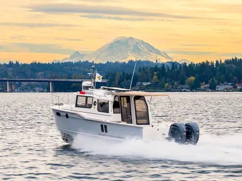Ranger Tugs R-27 with twin Yamaha outboards running in profile with Mount Rainier behind