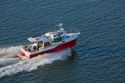Ranger Tugs R-29 S seen from above at speed showing the cockpit, cabin top and red hull