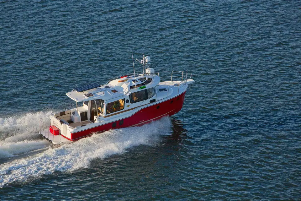 Ranger Tugs R-29 S seen from above at speed showing the cockpit, cabin top and red hull