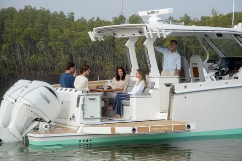 Regal 34 SAV aft cockpit with guests at the dinette beside the outboards and hardtop