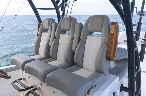 Regulator 41 helm with three gray quilted bolster seats and a teak armrest