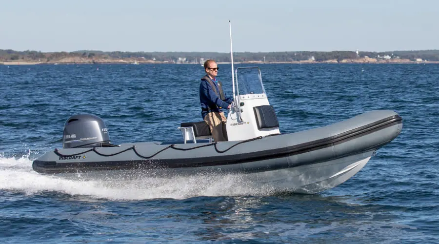 RIBCRAFT 5.85 rigid inflatable with a gray tube running fast with one person at the console