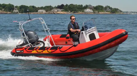 Red RIBCRAFT 5.85 rigid inflatable running at speed with a stern frame and outboard
