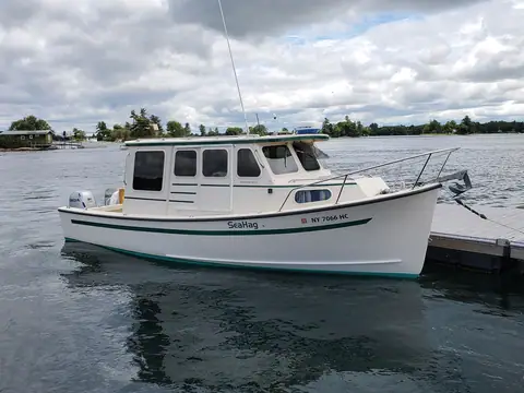 Rosborough RF 246 tied to a dock showing its pilothouse, cabin windows and bow pulpit