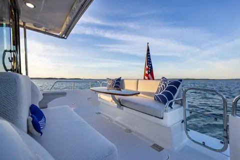 Sabre 38 Salon Express cockpit with settee, table and open transom gate at sunset