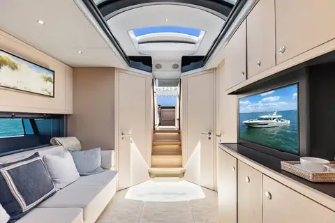 Lower salon of the Scout 670 LXS with a sofa, television and overhead skylight