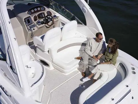 Couple on the cockpit lounge of a Sea Ray 340 Sundancer beside the helm