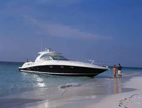 Sea Ray 420 Sundancer anchored off a white sand beach in profile