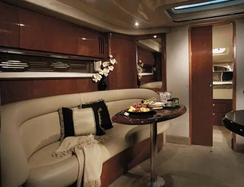 Main cabin of the Sea Ray 420 Sundancer with a curved settee and cherry joinery
