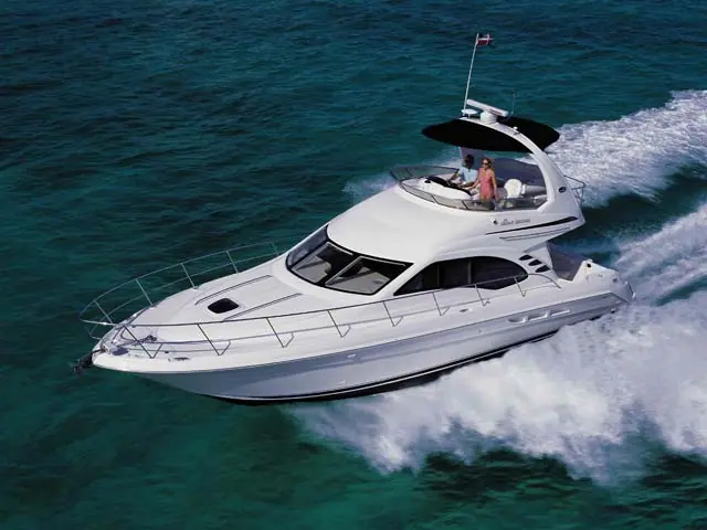 Aerial view of a Sea Ray 44 Sedan Bridge running fast with guests on the flybridge