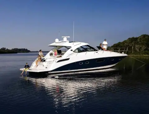Sea Ray 470 Sundancer at rest on calm water with guests on the swim platform and foredeck