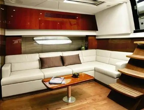 Sea Ray 470 Sundancer salon with a white L shaped settee and cherry cabinetry