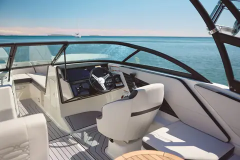 Helm and bucket seat of the Sea Ray SPX 210 Outboard behind the windshield