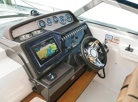Helm of the Sea Ray Sundancer 350 Coupe with a large touchscreen and gauges