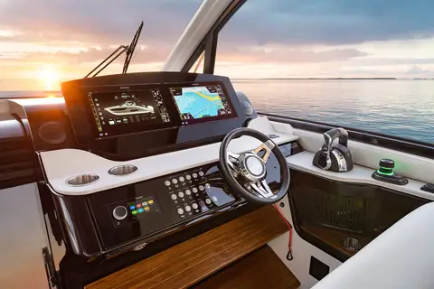 Sea Ray Sundancer 370 Outboard helm with twin glass displays and sport wheel at sunset
