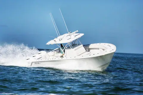 SeaHunter 33 Tournament center console running at speed with a white hardtop and outriggers