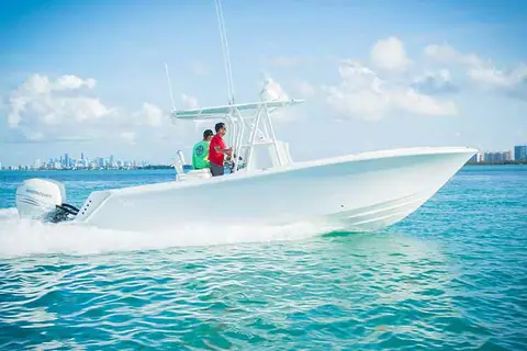 SeaVee 290B running in profile on turquoise water off Miami with two anglers at the console
