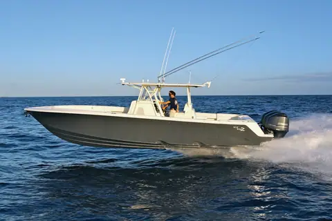 SeaVee 390Z running in profile at dusk with outriggers raised and a white hardtop