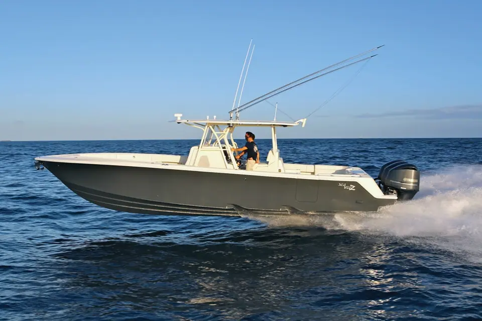 SeaVee 390Z running in profile at dusk with outriggers raised and a white hardtop