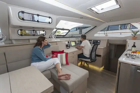 Seawind 1600 saloon with lounge, forward nav station and galley under wide windows