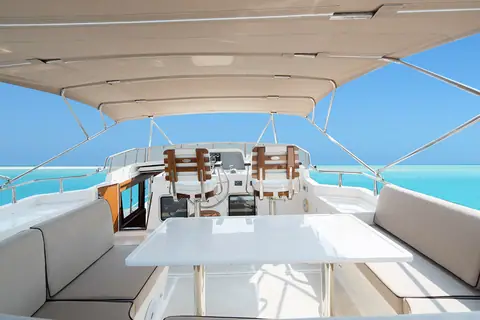 Selene 49 flybridge with upper helm seats, dinette table and a hardtop overhead
