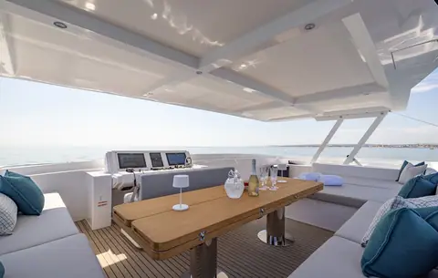 Silent 60 flybridge with a teak dining table, lounge seating and the upper helm