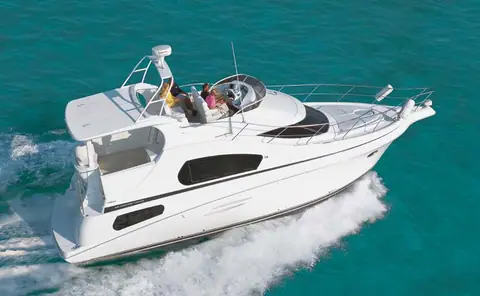 Silverton 39 Motor Yacht running fast over turquoise water with guests on the flybridge