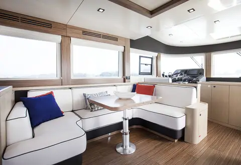 Sirena 58 main deck dinette with white upholstery beside large saloon windows