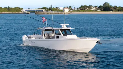 Solace 42CS cruising slowly near an inlet with outriggers raised