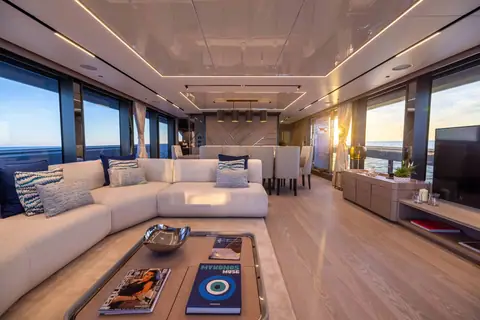 Sunseeker 100 Yacht main saloon with a large sofa, coffee table and full height windows