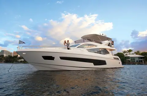 Sunseeker 75 Yacht Mk2 at anchor in profile with guests on the foredeck and flybridge