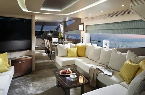 Sunseeker 75 Yacht Mk2 saloon with a large cream sofa, yellow cushions and dining area beyond