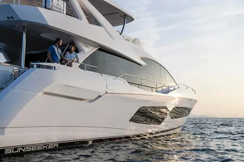 Sunseeker 76 Yacht side deck and flybridge overhang with guests at the rail at sunset