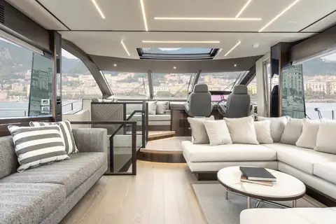 Sunseeker 76 Yacht saloon with L shaped sofa, round coffee table and raised helm forward