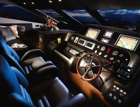 Lower helm of the Sunseeker 80 Yacht with chart displays and a wooden wheel