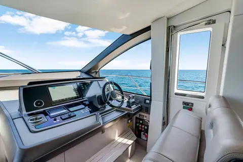 Sunseeker Manhattan 68 lower helm station with screens, wheel and a side deck door