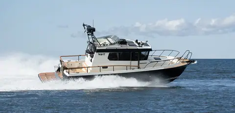 Targa 32 with a dark hull running at speed on open water, Targa 32 lettering on the wheelhouse