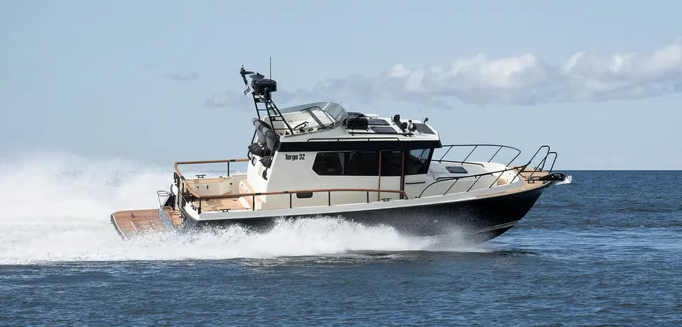 Targa 32 with a dark hull running at speed on open water, Targa 32 lettering on the wheelhouse
