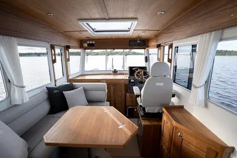 Targa 32 wheelhouse with teak joinery, dinette table, helm seat and wraparound windows
