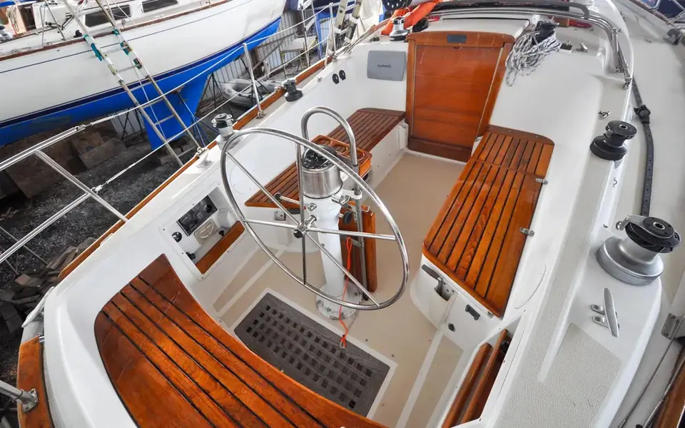 T shaped cockpit of a 1982 Tartan 37 with teak seats and a destroyer wheel