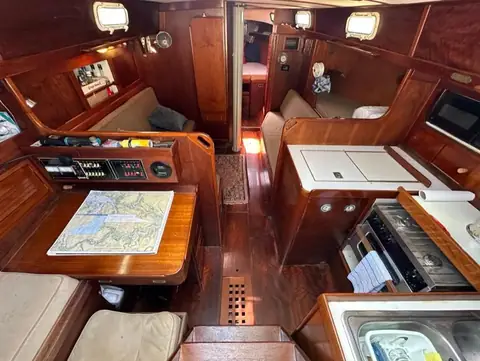 Teak main cabin of a 1978 Tartan 37 with nav station, settees and galley
