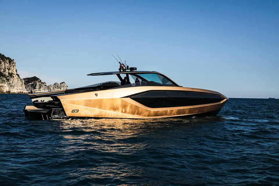 Gold Tecnomar for Lamborghini 63 at rest in profile near white cliffs, with its 63 logo on the hull