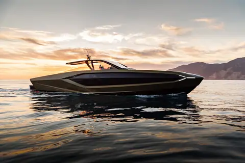 Dark Tecnomar for Lamborghini 63 drifting at sunset, showing its angular hull and wraparound windshield