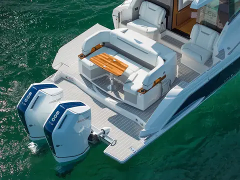 Tiara 43 LE aft cockpit with U shaped lounge, teak table and twin Mercury Verado V12 outboards