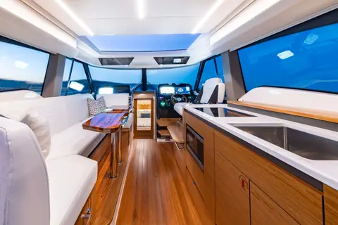 Tiara 43 LE salon with galley, settee, teak floor and the helm forward under a skylight