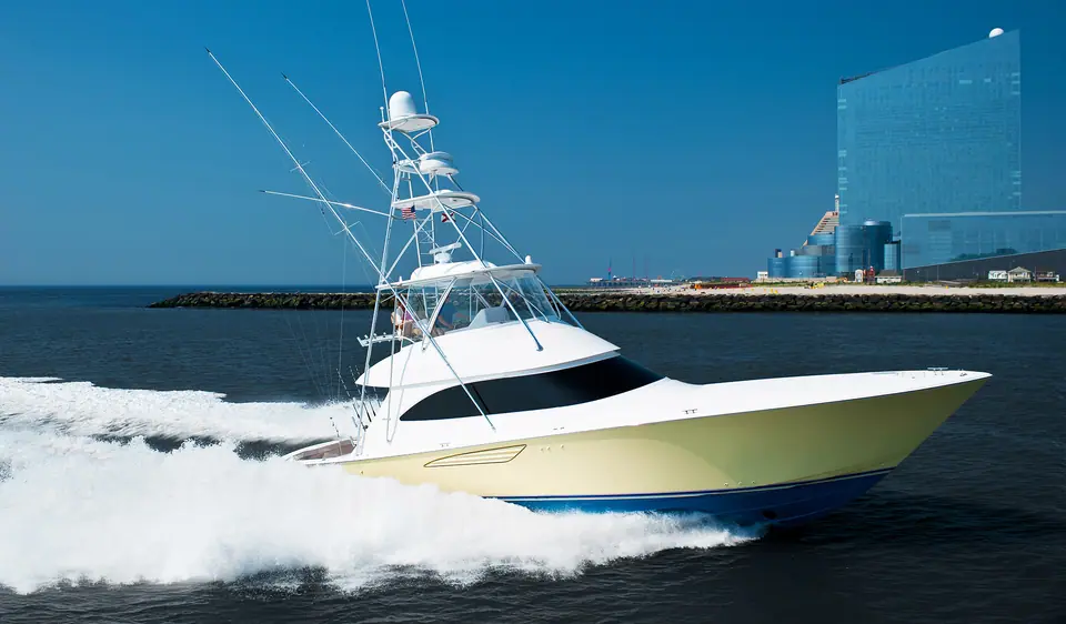 Viking 52 Convertible running past a breakwater and high rise skyline