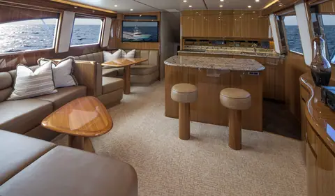 Viking 55 Convertible salon with leather settee, galley island with stools and satin wood joinery