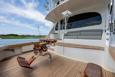 Viking 70 Enclosed Bridge teak cockpit with an offset fighting chair and mezzanine seating
