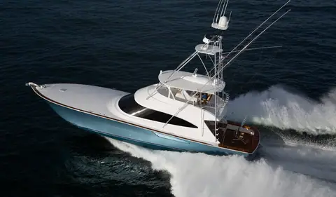 Viking 72 Convertible crossing open water at speed with outriggers and teak cockpit visible